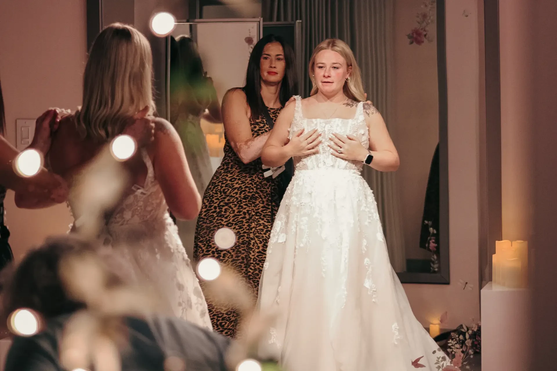 image shows a woman trying on wedding dresses