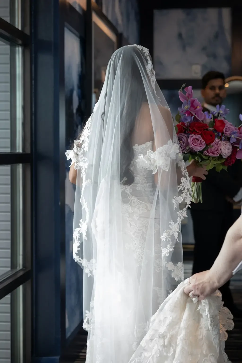 image shows a model wearing a wedding dress and a long veil