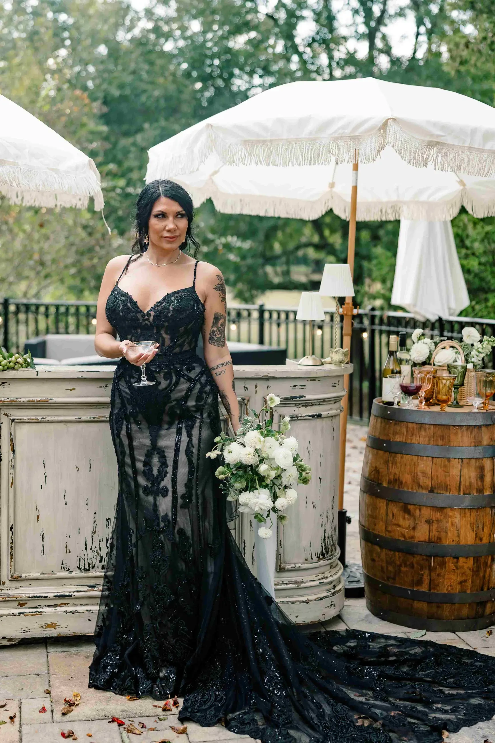 bride is wearing a sleeveless spaghetti strap black lace fit and flare wedding dress