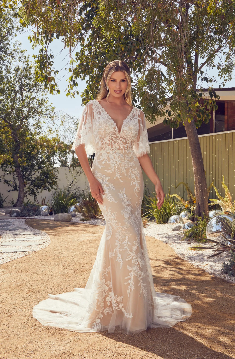 model is wearing a bohemian wedding dress inspired by taylor swift's folklore era