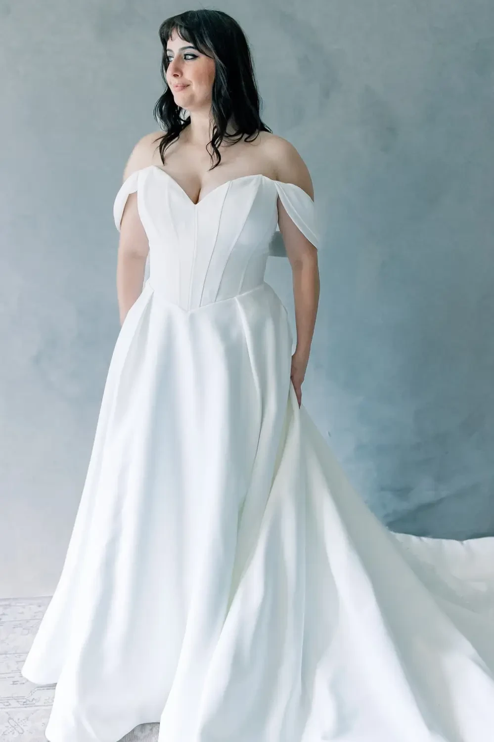 Model wearing a basque waist wedding dress