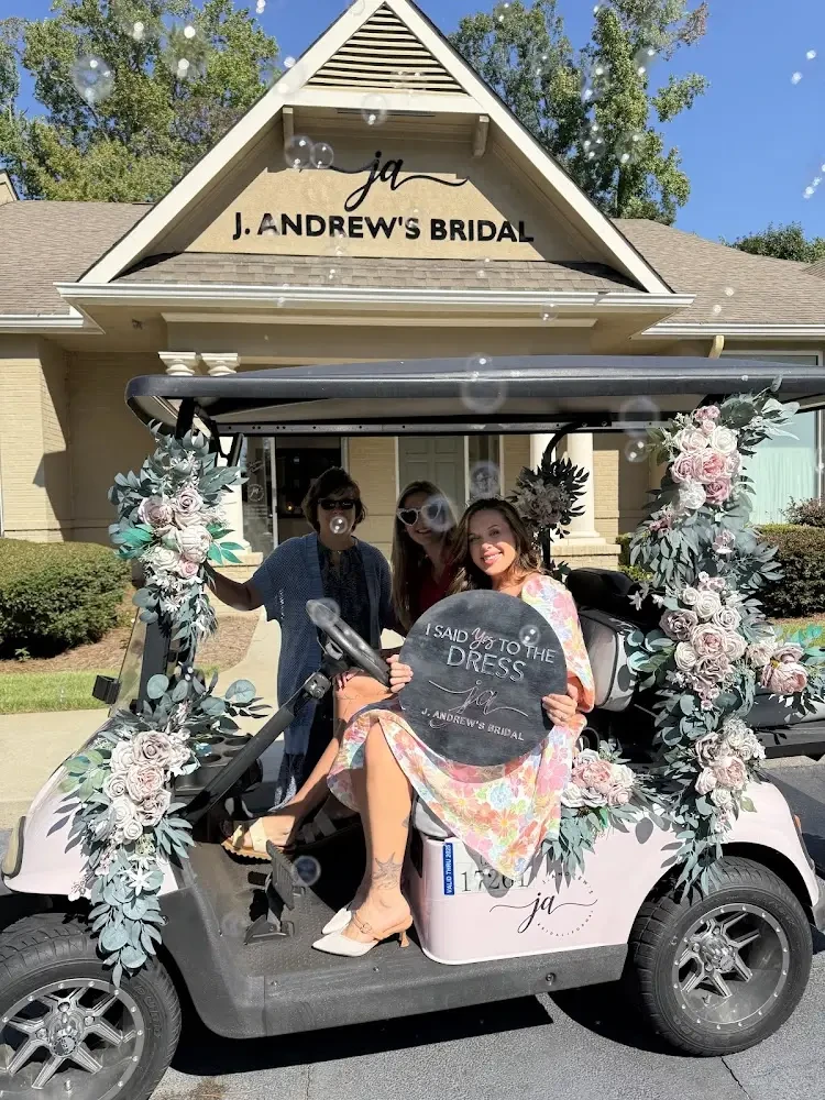 image shows a bride showing her said yes to the dress sign on a golf cart at j andrews bridal